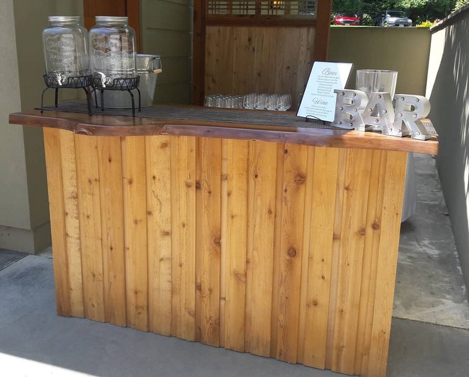 A wooden mobile bar with a live-edge bar top.