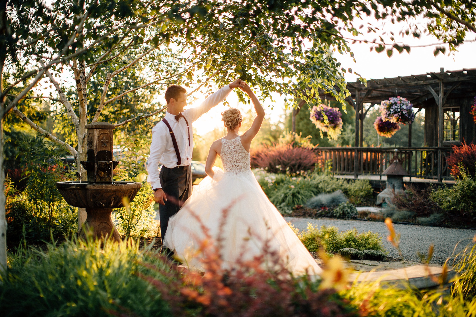 newlyweds dancing next to a fountain in front of a 100-year old barn