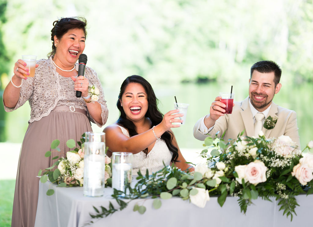 a couple raising their glass with smiles on their faces as they cheers to a toast