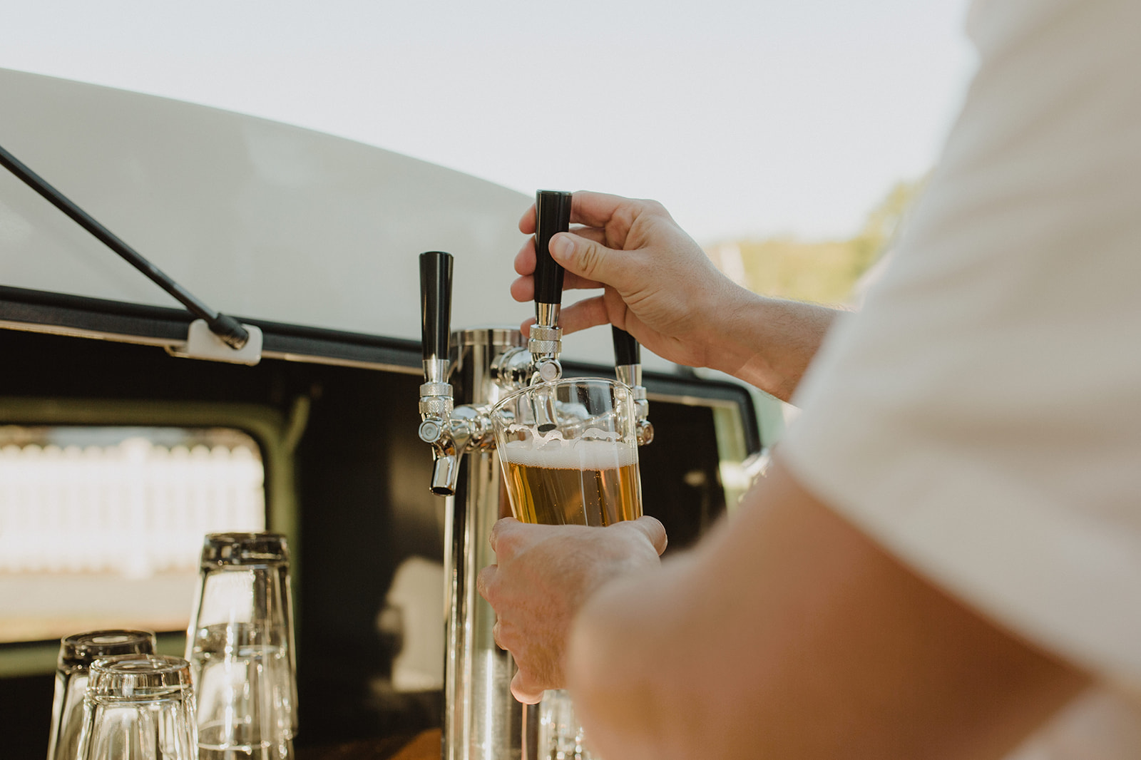 bartender pouring a draft beer from a keg