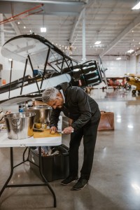 mobile bartender for hire in gig harbor cutting fruit with a vintage airplane in the background