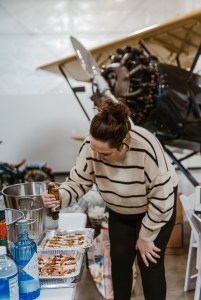 caterer prepping the appetizers with a vintage airplane in the background